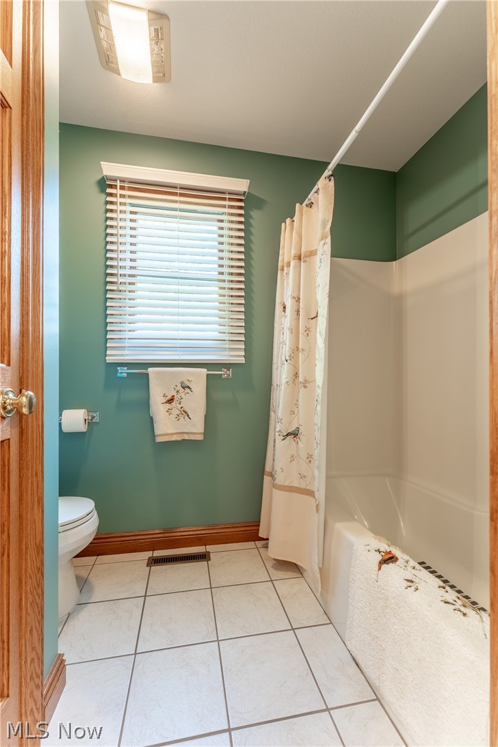 20 Reedsburg Road Wooster, OH 44691 - Photo 17 of 42 Bathroom with tile floors, shower / bath combination with curtain, and toilet