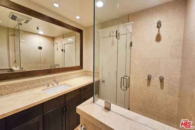 a bathroom with a shower sink and mirror
