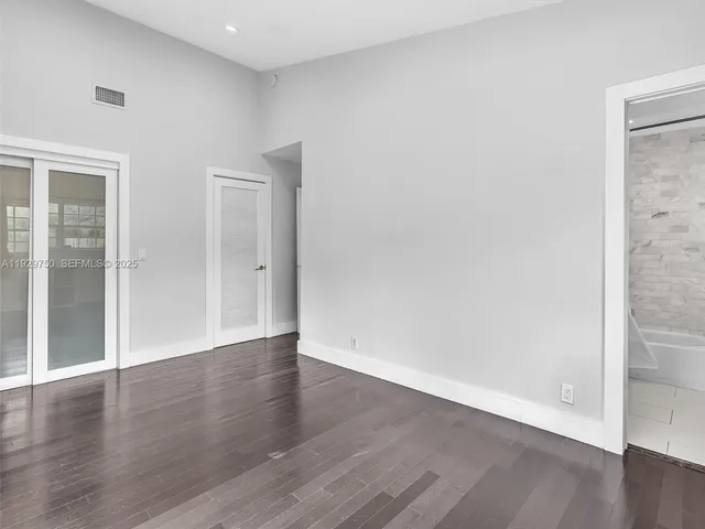 a view of an empty room with wooden floor