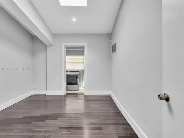 a view of a room with wooden floor and a window