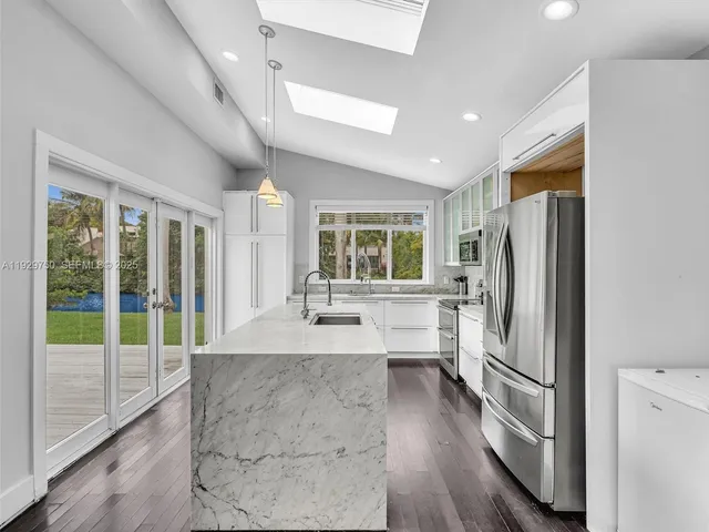 a kitchen with stainless steel appliances granite countertop a refrigerator and a stove