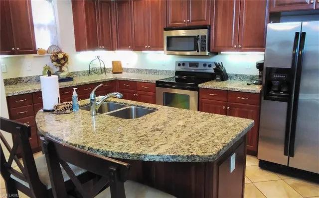 a kitchen with granite countertop wood cabinets a sink and appliances