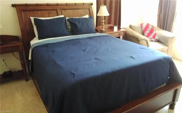 a bed sitting in a bedroom next to a window