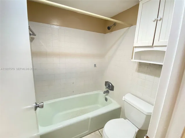 a white toilet sitting next to a bath tub