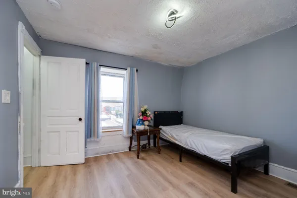 a bedroom with a bed and wooden floor
