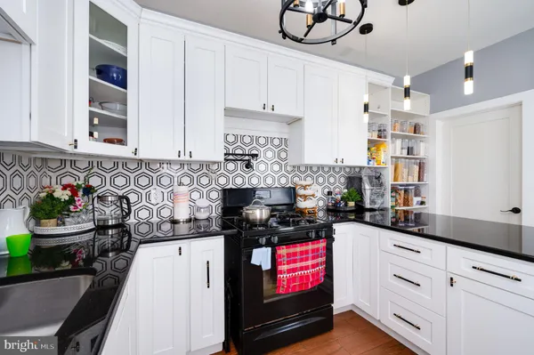 a kitchen with stainless steel appliances a stove a sink cabinets and a window