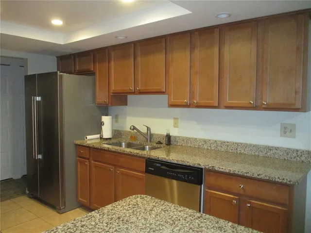 a kitchen with a sink a refrigerator and cabinets