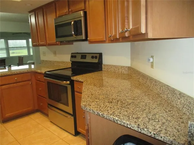 a kitchen with stainless steel appliances granite countertop a sink stove and microwave