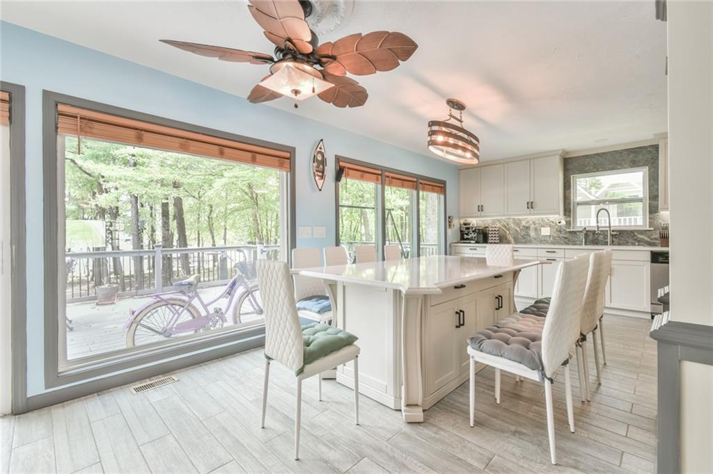 591 Rue Cezzan Lavonia, GA 30553 - Photo 15 of 36 a dining room with wooden floor a chandelier fan a glass table and chairs