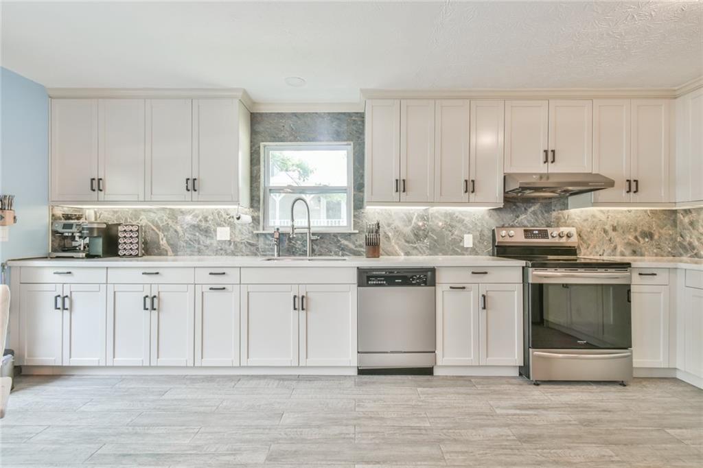 591 Rue Cezzan Lavonia, GA 30553 - Photo 7 of 36 a kitchen with granite countertop white cabinets and white appliances