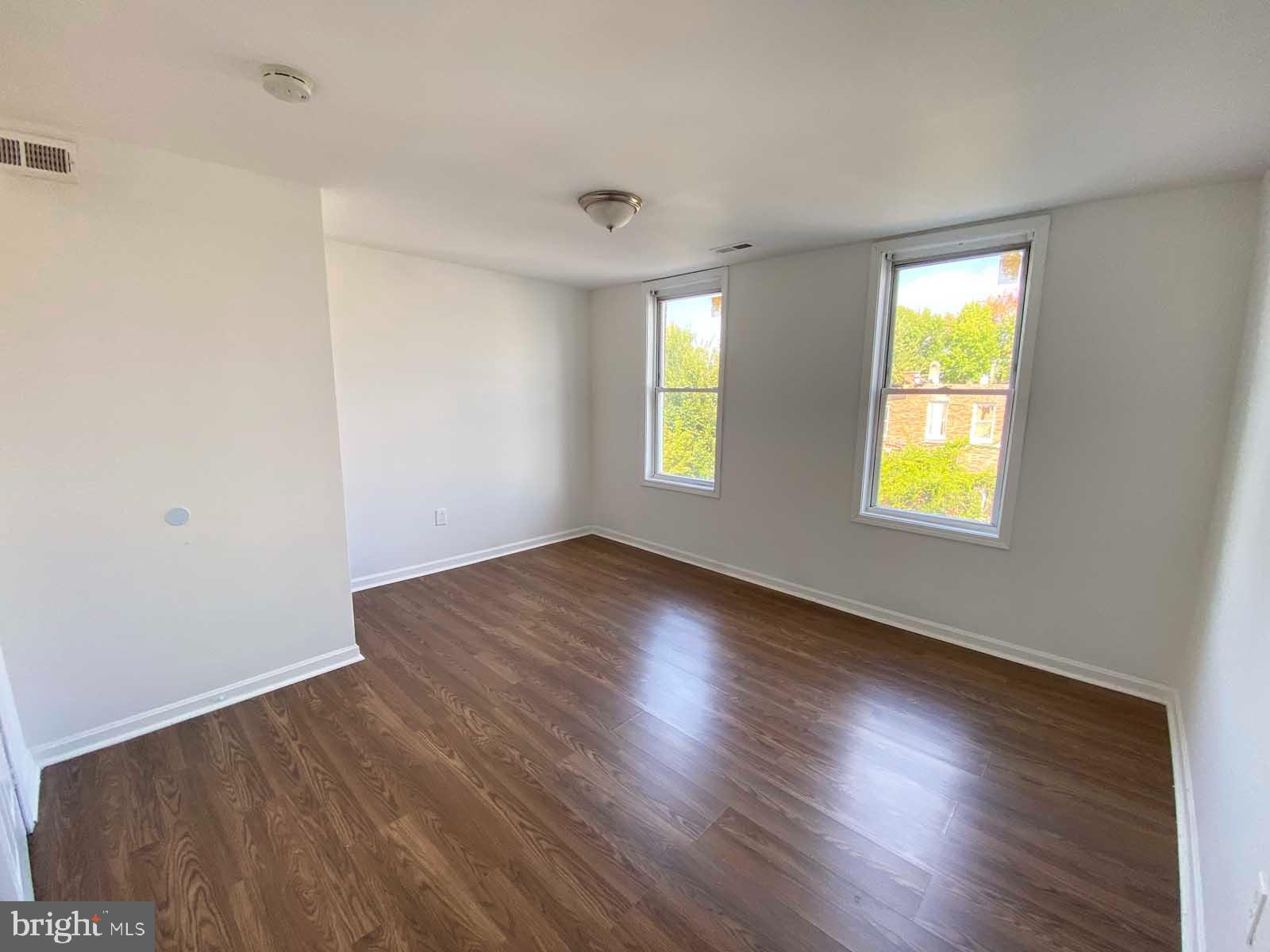 3015 Rayner Avenue Baltimore, MD 21216 - Photo 15 of 71 a view of an empty room with wooden floor and two window
