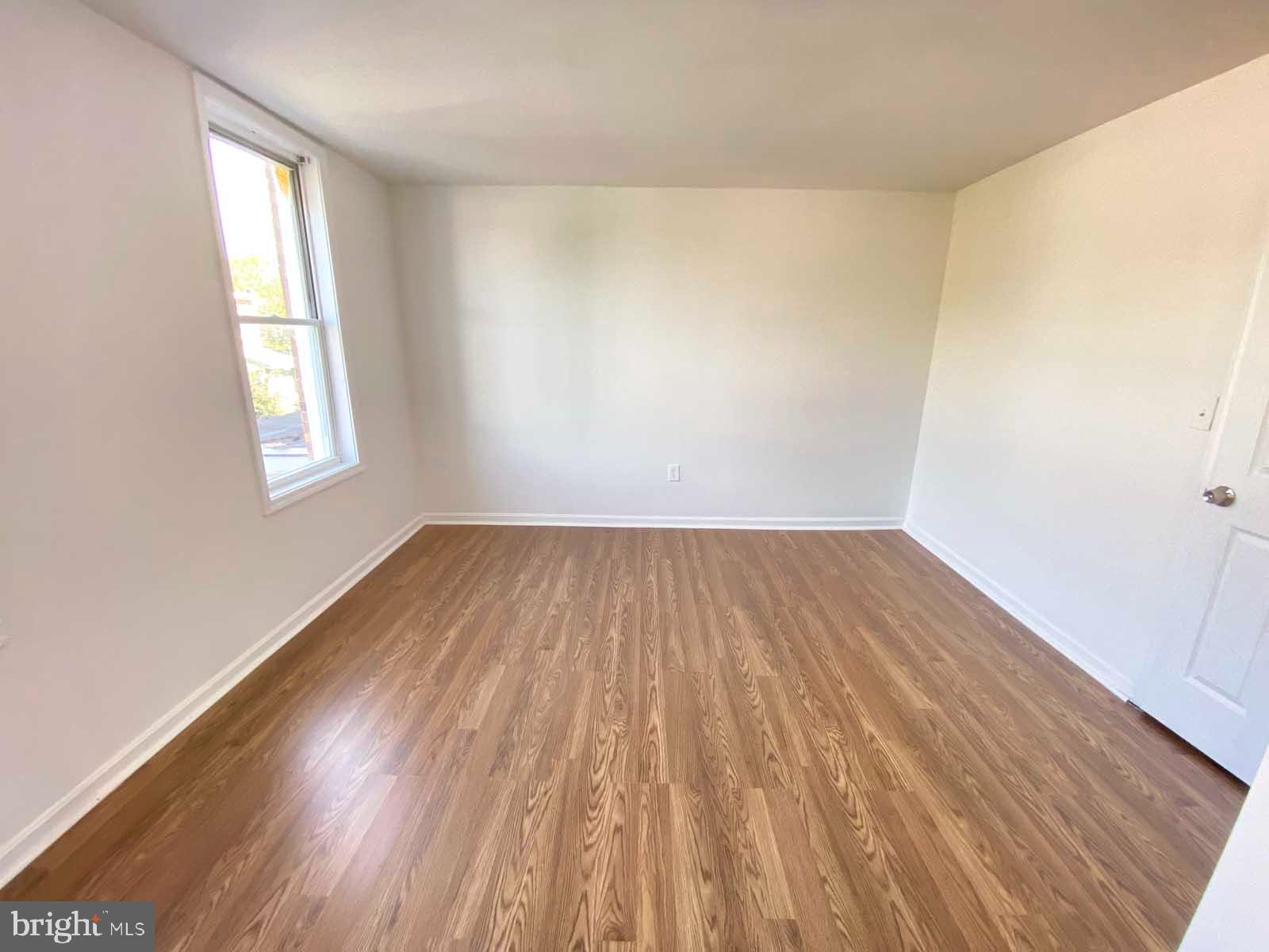 3015 Rayner Avenue Baltimore, MD 21216 - Photo 17 of 71 an empty room with wooden floor and windows