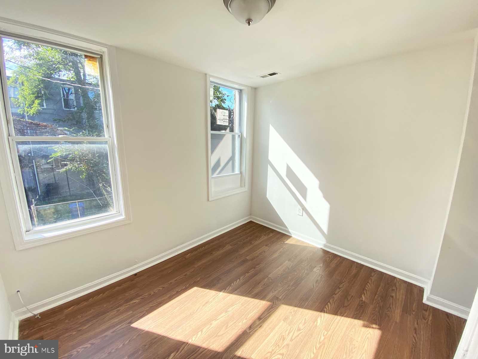3015 Rayner Avenue Baltimore, MD 21216 - Photo 2 of 71 an empty room with wooden floor and windows