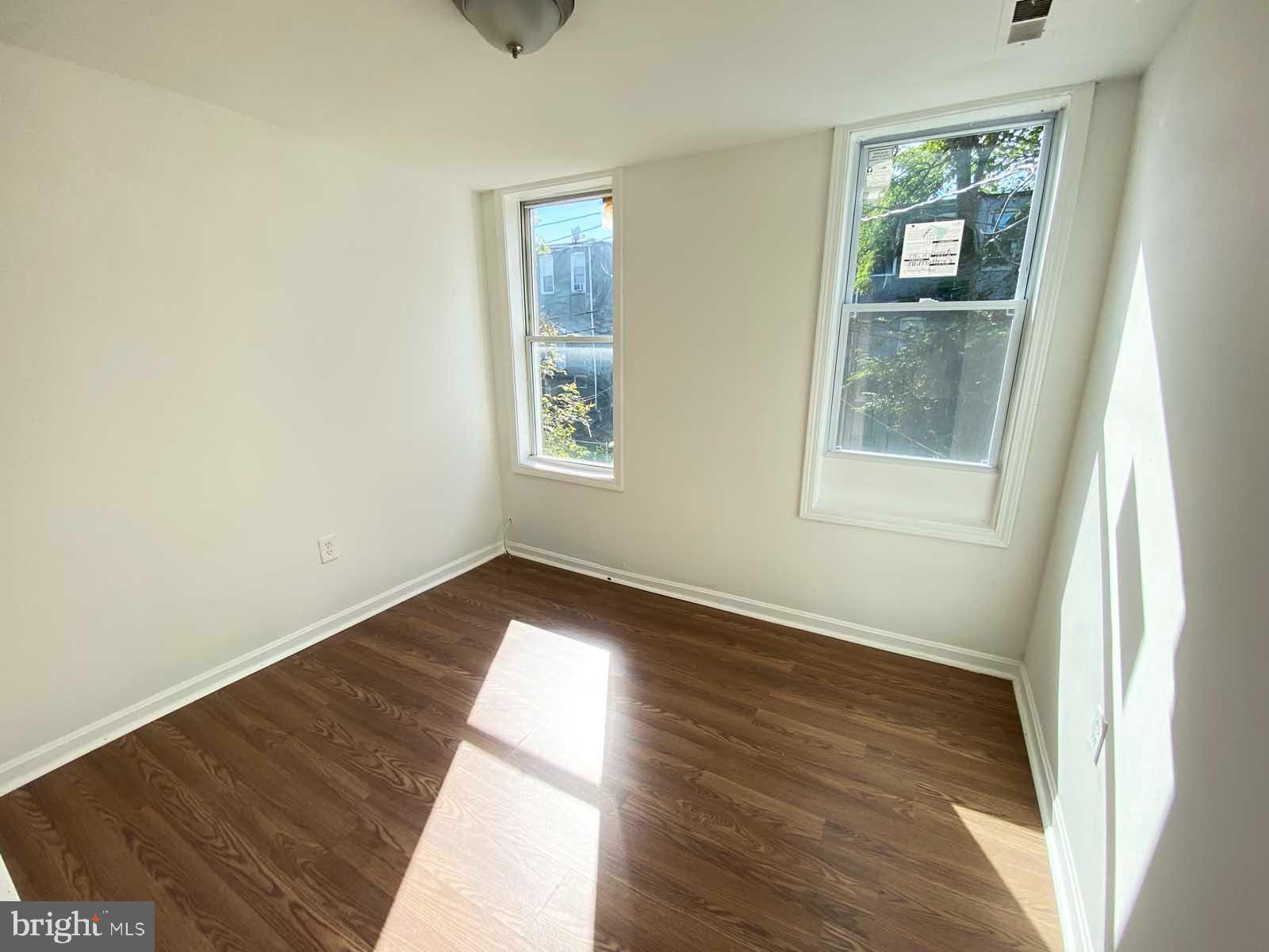 3015 Rayner Avenue Baltimore, MD 21216 - Photo 6 of 71 a view of an empty room with wooden floor and a window
