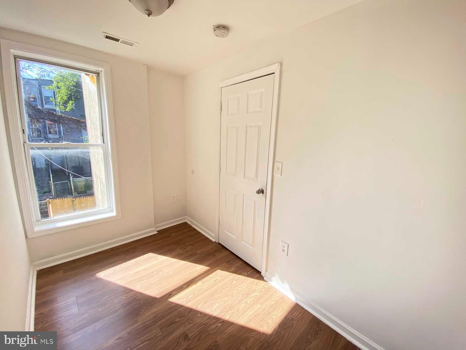 3015 Rayner Avenue Baltimore, MD 21216 - Photo 8 of 71 a view of an empty room with wooden floor and a window