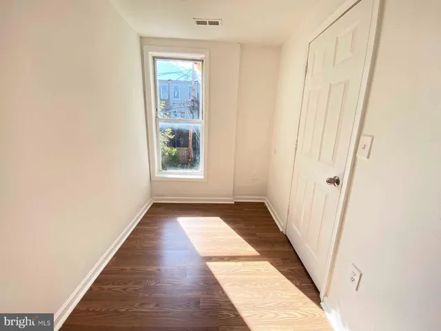 a view of a hallway with wooden floor and a window