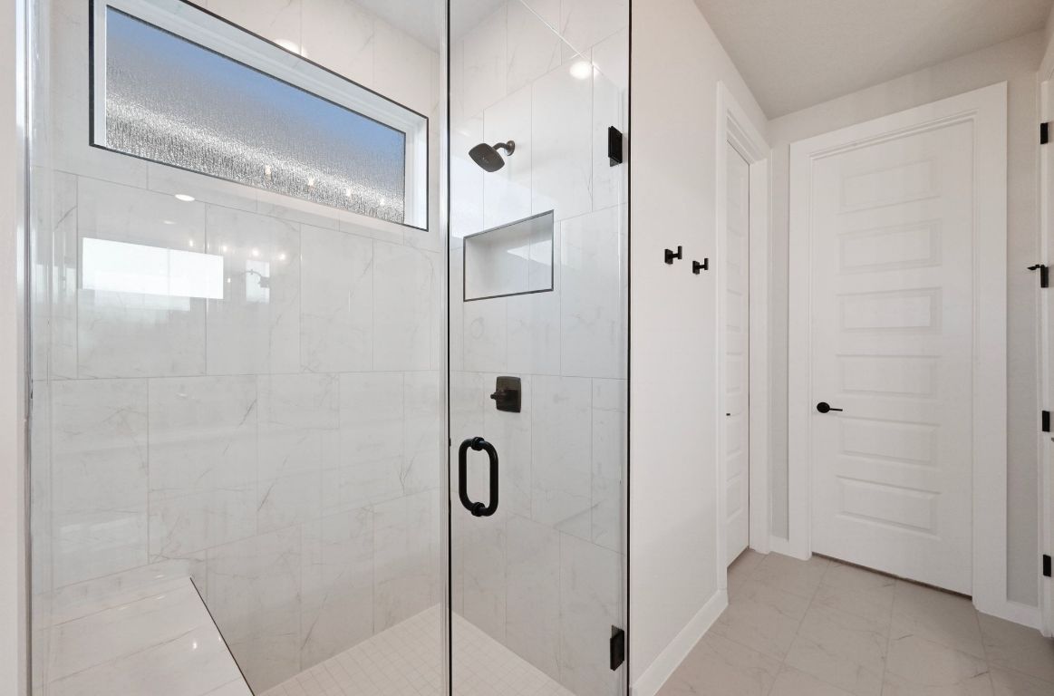 144 Granit Oak Drive Dripping Springs, TX 78620 - Photo 14 of 33 a bathroom with a glass shower door
