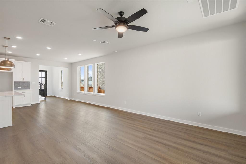 144 Granit Oak Drive Dripping Springs, TX 78620 - Photo 4 of 33 a view of an empty room with wooden floor and a ceiling fan