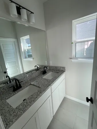 a bathroom with a granite countertop sink and a mirror