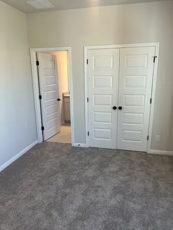 an empty room with closet and mirror