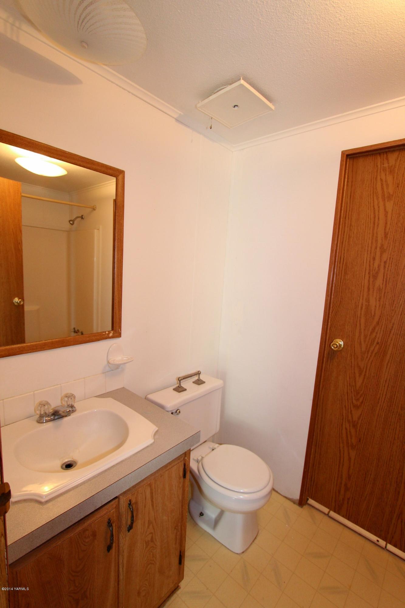 12381 Postma Road Moxee, WA 98936 - Photo 12 of 20 a bathroom with a sink a toilet and mirror