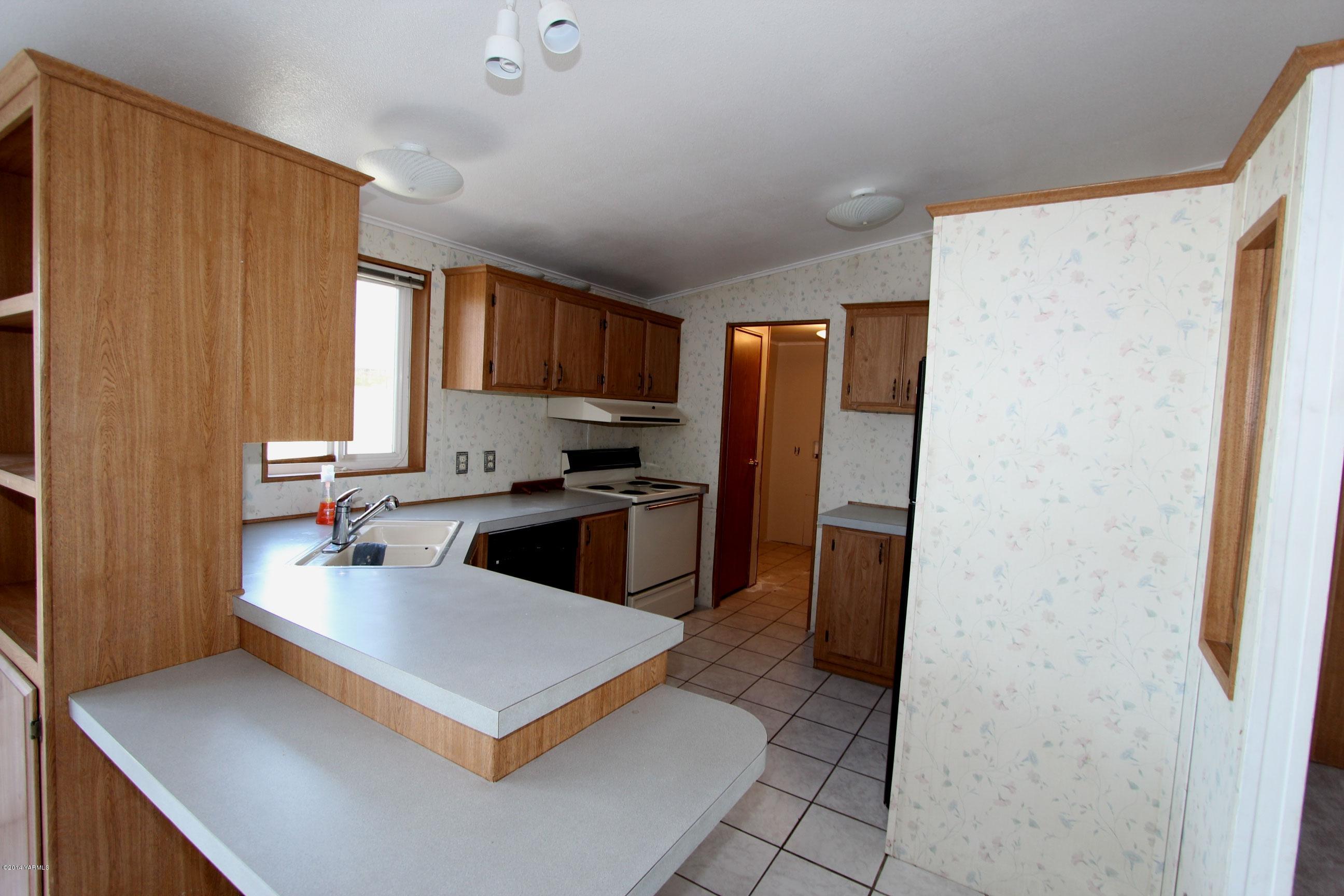 12381 Postma Road Moxee, WA 98936 - Photo 15 of 20 a kitchen with stainless steel appliances a refrigerator sink and cabinets
