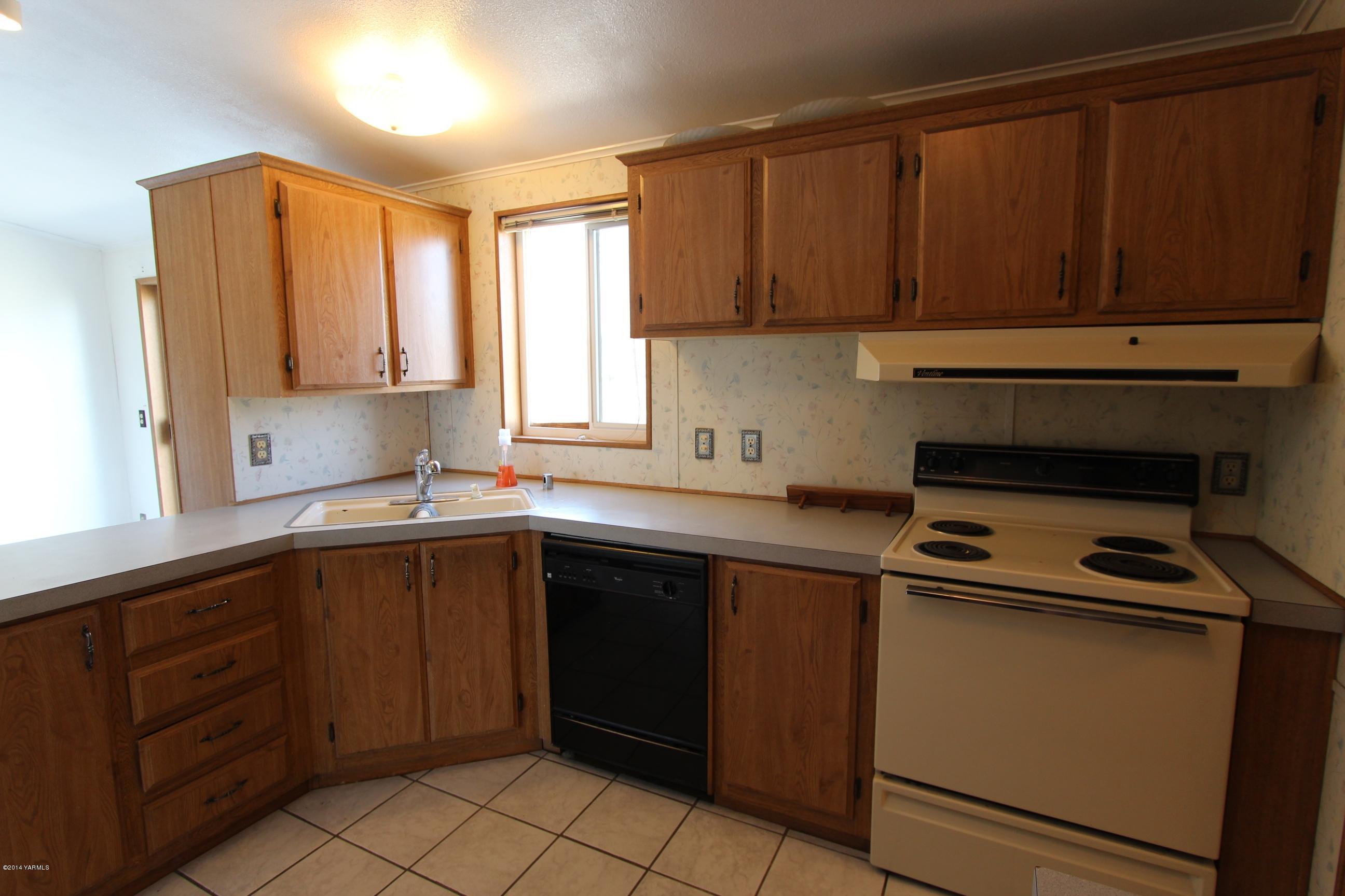 12381 Postma Road Moxee, WA 98936 - Photo 19 of 20 a kitchen with a sink window and cabinets