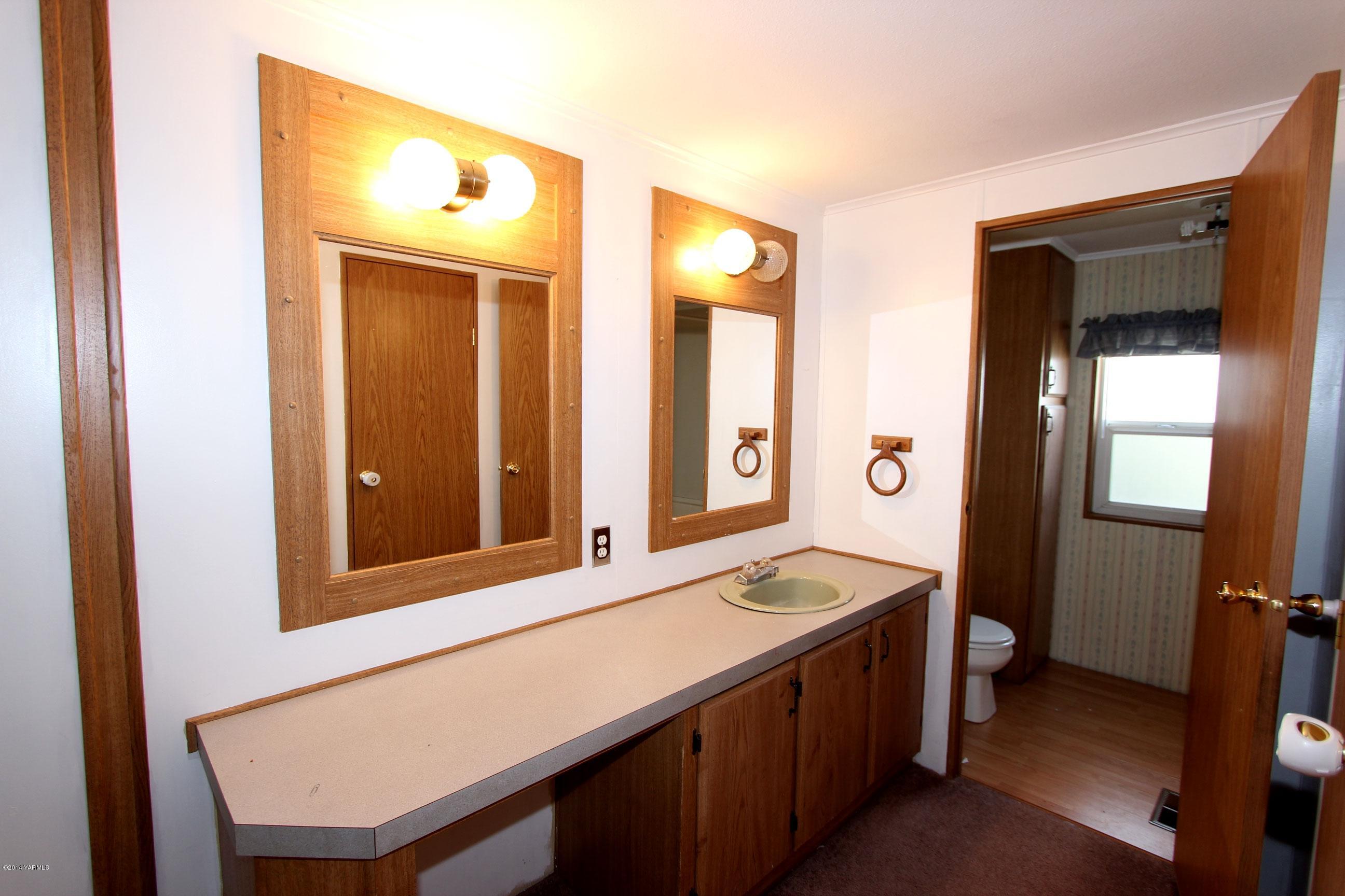 12381 Postma Road Moxee, WA 98936 - Photo 6 of 20 a bathroom with a sink a mirror and a bathtub