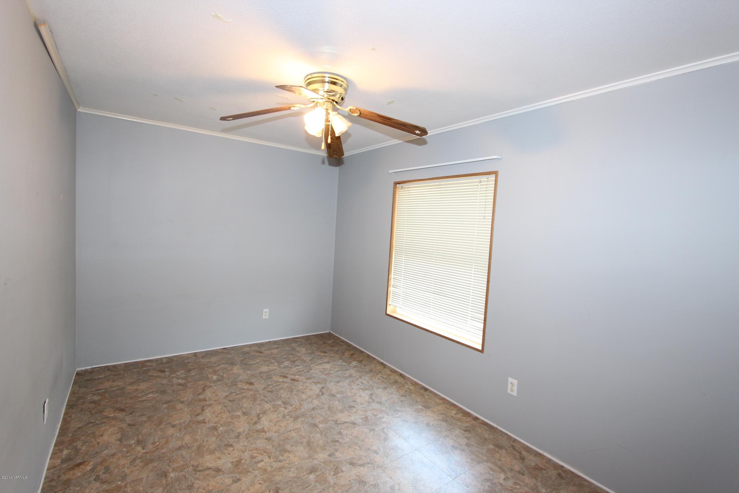 12381 Postma Road Moxee, WA 98936 - Photo 10 of 20 an empty room with windows and chandelier fan