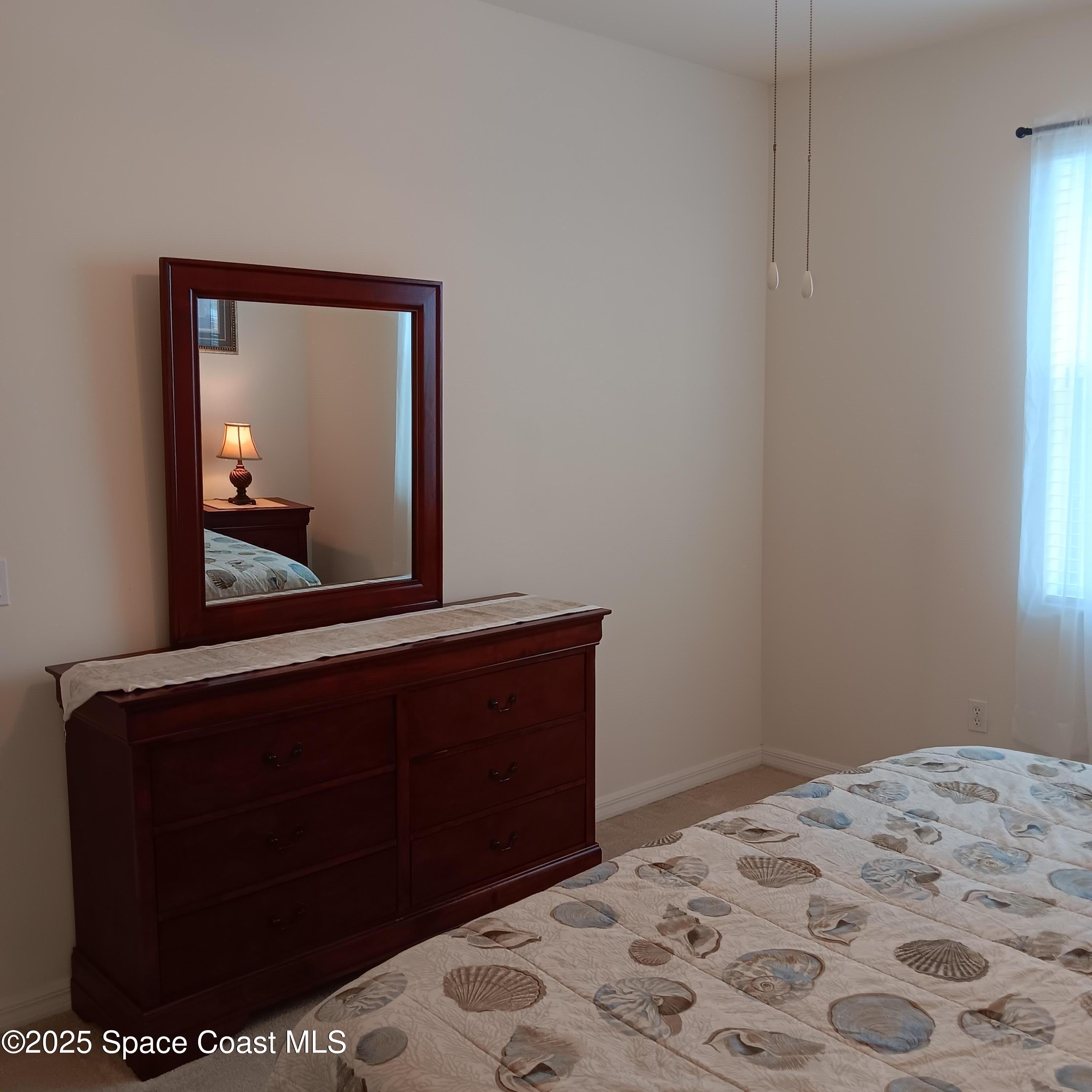 6858 Toland Drive, Unit 304 Melbourne, FL 32940 - Photo 12 of 31 a room with a bed and a mirror