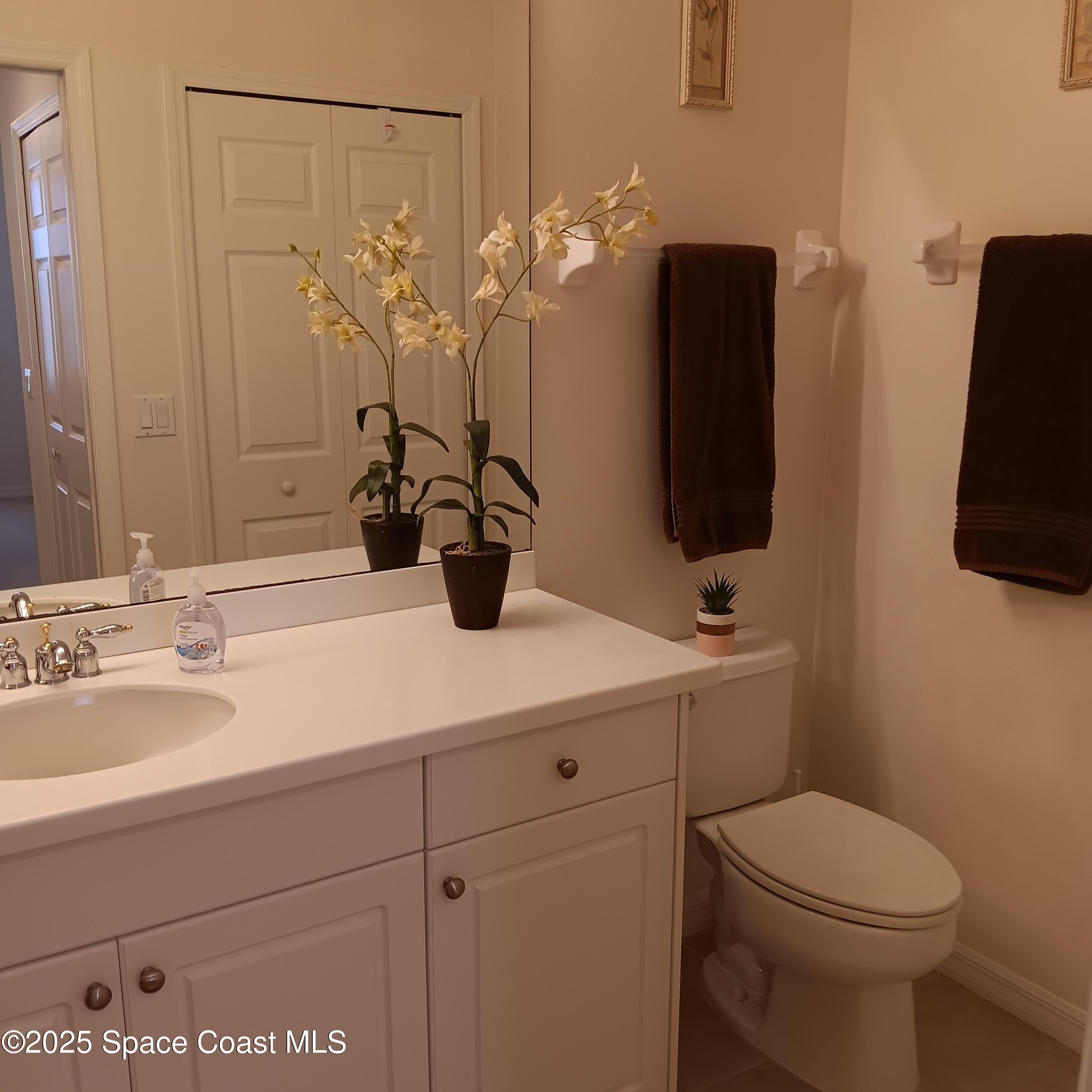 6858 Toland Drive, Unit 304 Melbourne, FL 32940 - Photo 16 of 31 a bathroom with a sink a toilet and mirror