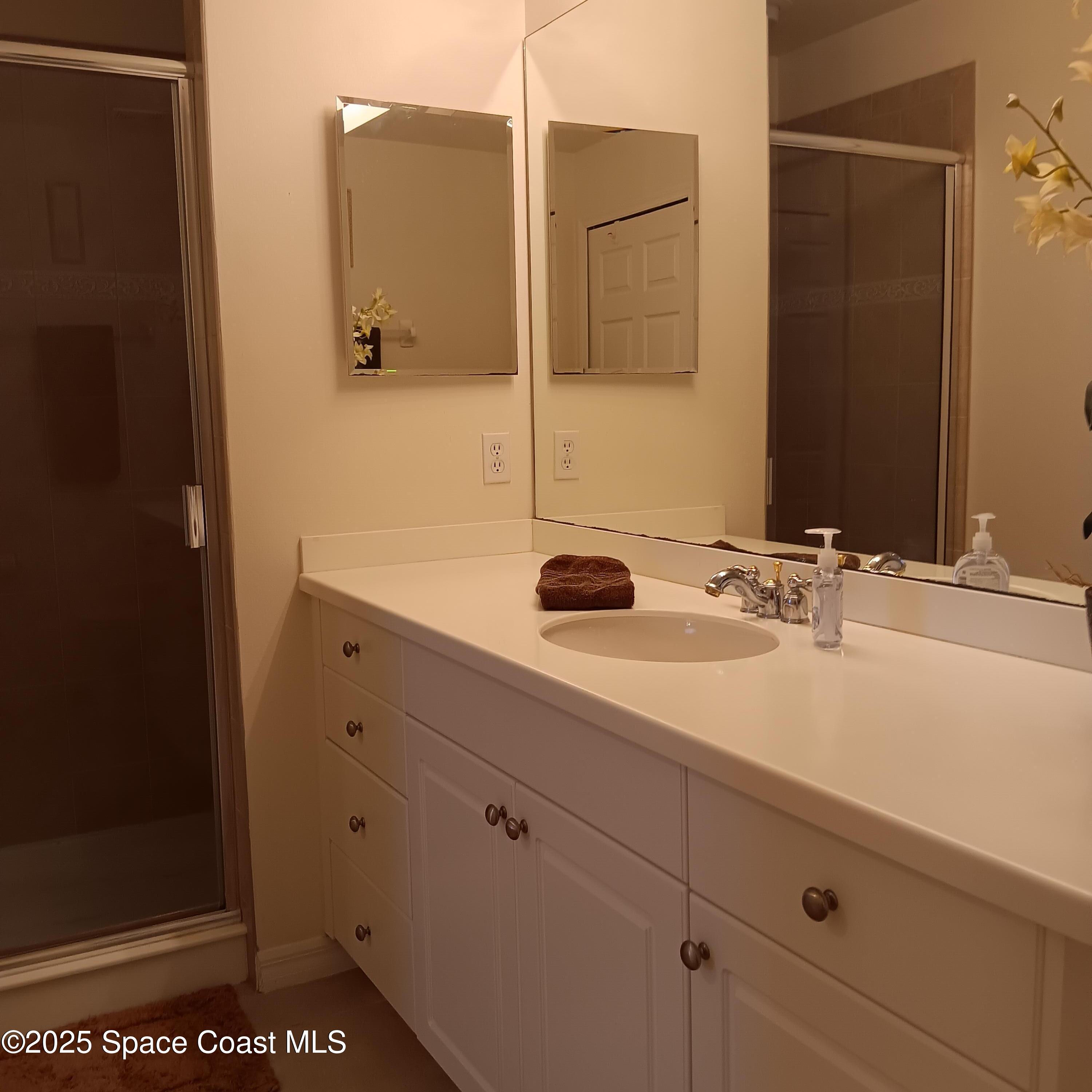 6858 Toland Drive, Unit 304 Melbourne, FL 32940 - Photo 17 of 31 a bathroom with a sink and a mirror