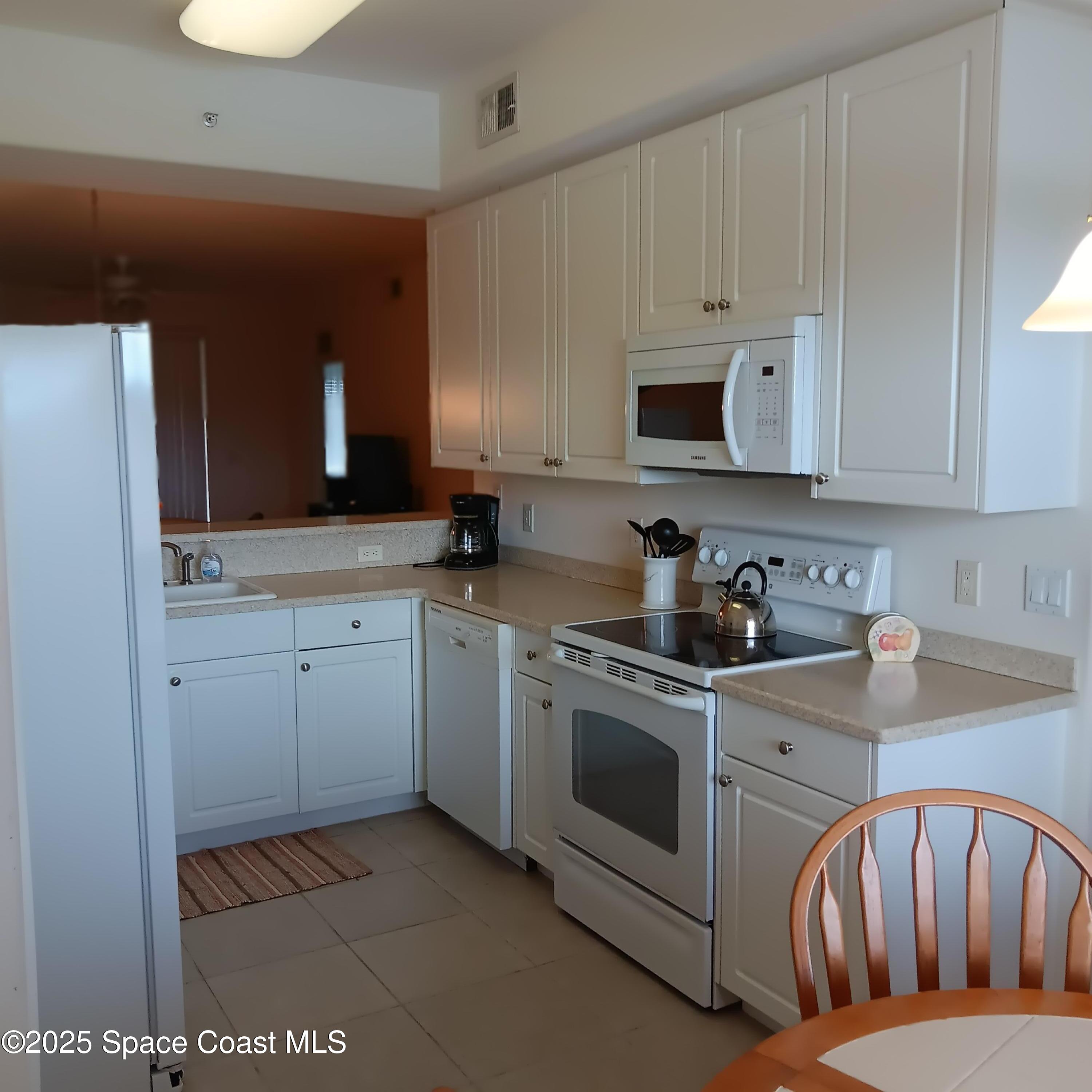 6858 Toland Drive, Unit 304 Melbourne, FL 32940 - Photo 6 of 31 a kitchen with a sink stove and cabinets