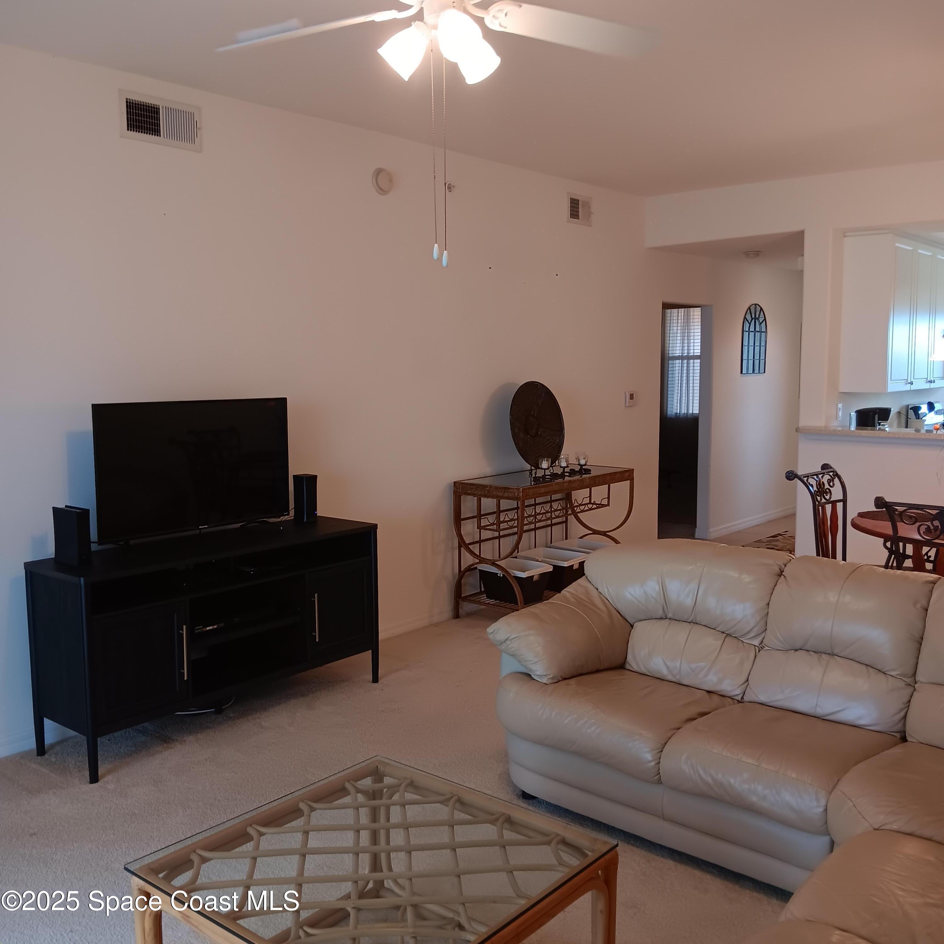 6858 Toland Drive, Unit 304 Melbourne, FL 32940 - Photo 8 of 31 a living room with furniture and a flat screen tv