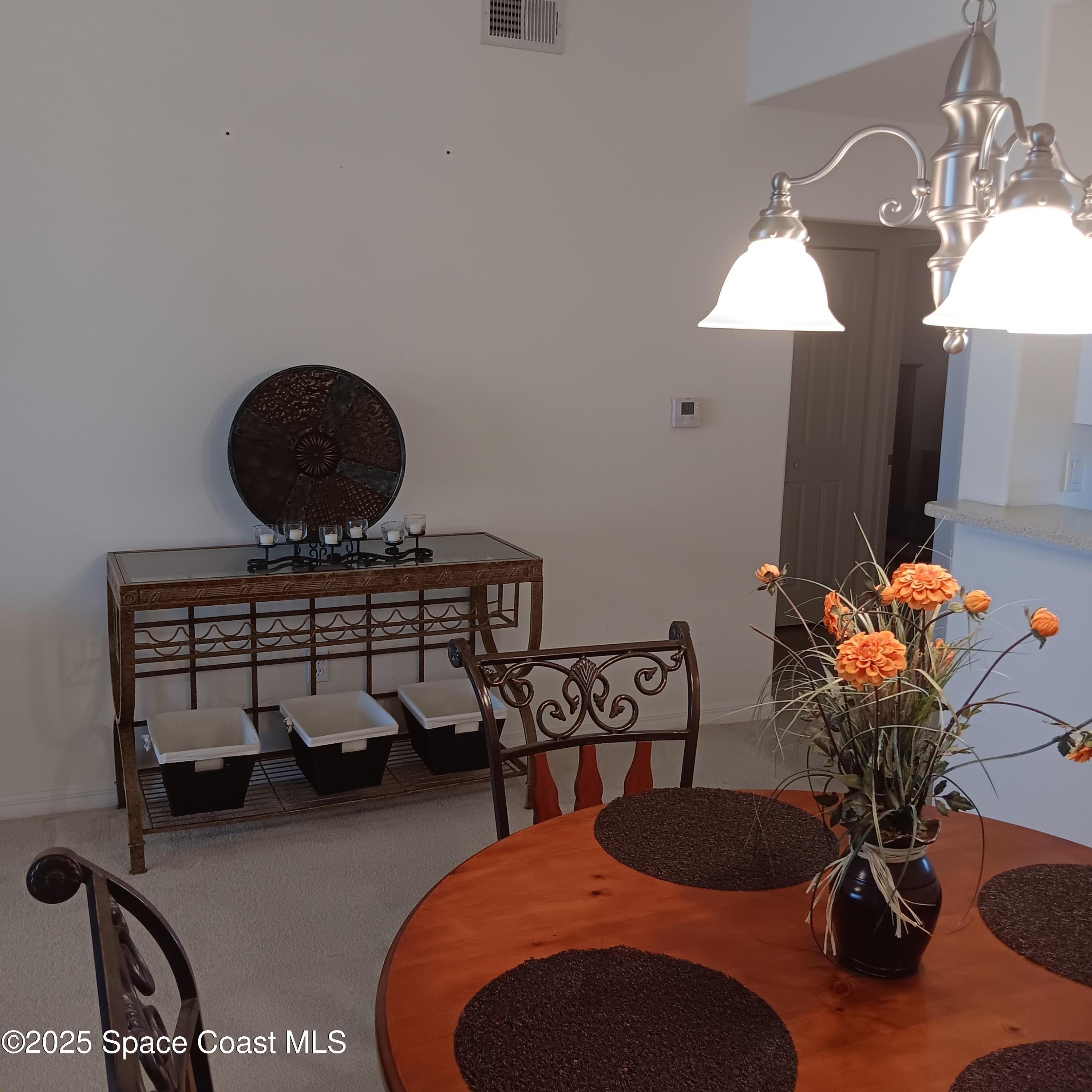 6858 Toland Drive, Unit 304 Melbourne, FL 32940 - Photo 10 of 31 a living room with furniture and a chandelier