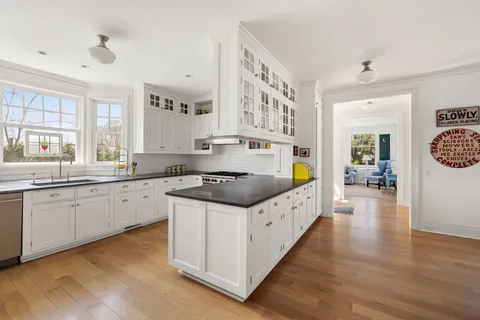 a kitchen with stainless steel appliances granite countertop a stove a sink and a white cabinets