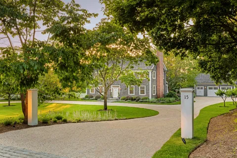 a view of a house with a garden and trees