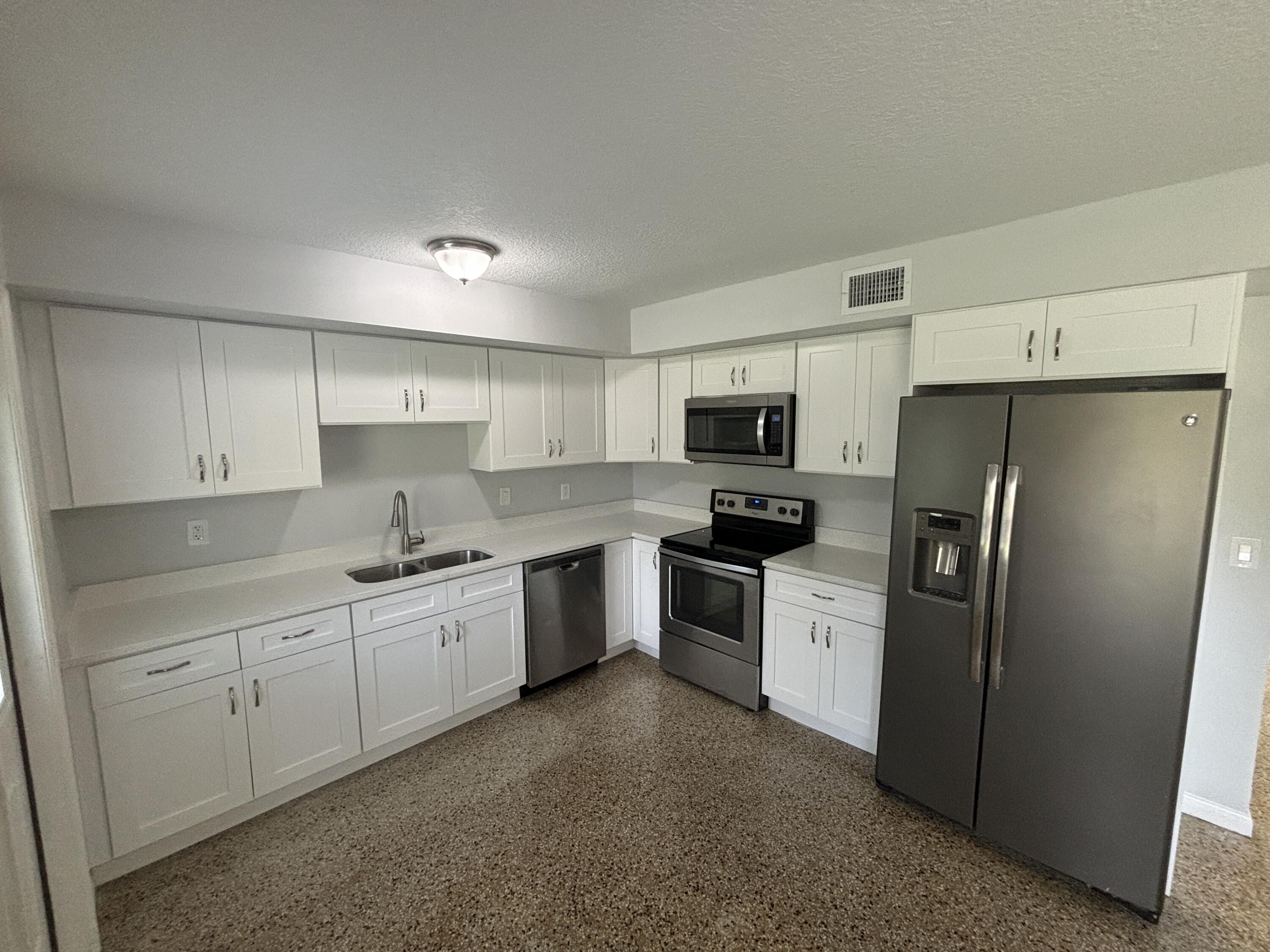 4305 Hammock Trail Mims, FL 32754 - Photo 7 of 16 a kitchen with stainless steel appliances a refrigerator sink stove and microwave