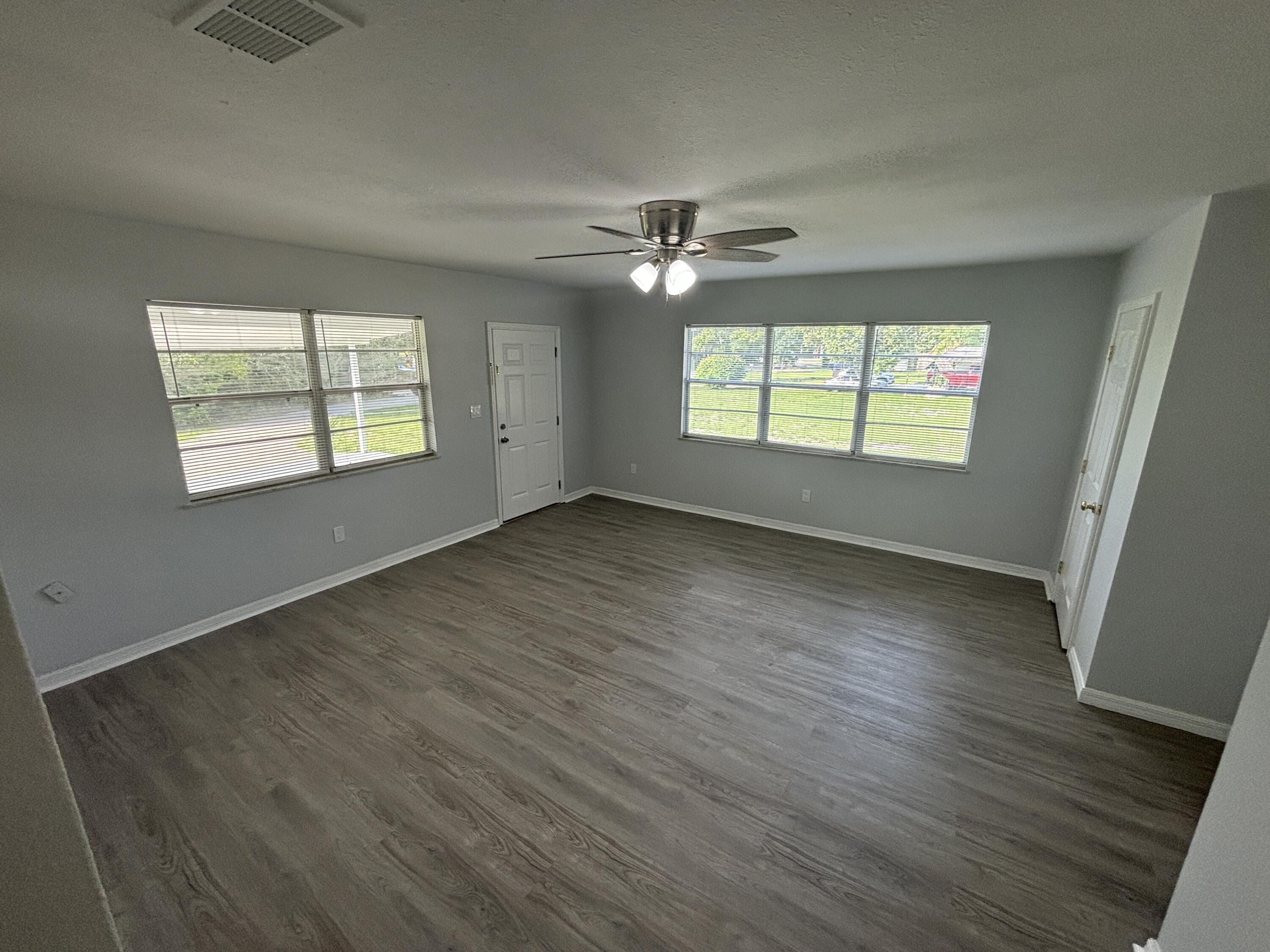 4305 Hammock Trail Mims, FL 32754 - Photo 8 of 16 an empty room with wooden floor ceiling fan and windows