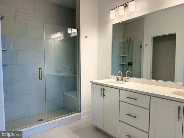 a bathroom with a shower sink and mirror