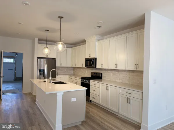 a kitchen with a sink a microwave a stove and refrigerator