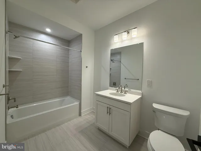 a bathroom with a sink toilet vanity and shower