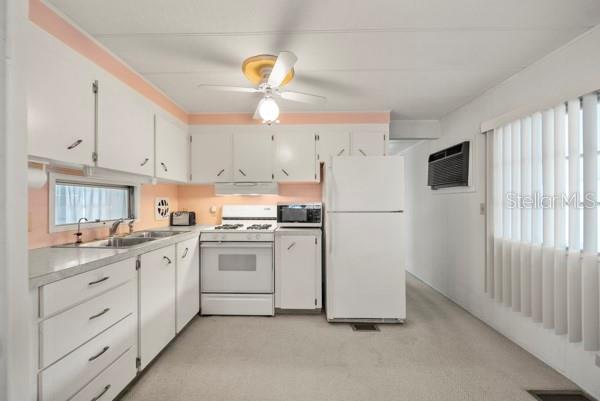 11047 102nd Way North, Unit 203 Largo, FL 33773 - Photo 3 of 26 a kitchen with cabinets appliances a sink and a window