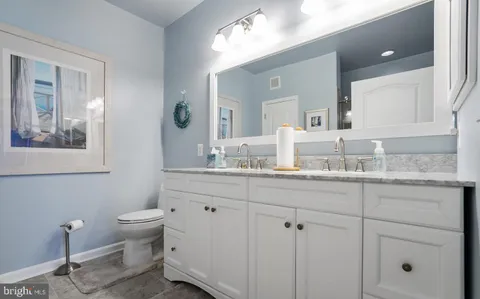 a bathroom with a granite countertop sink mirror and toilet