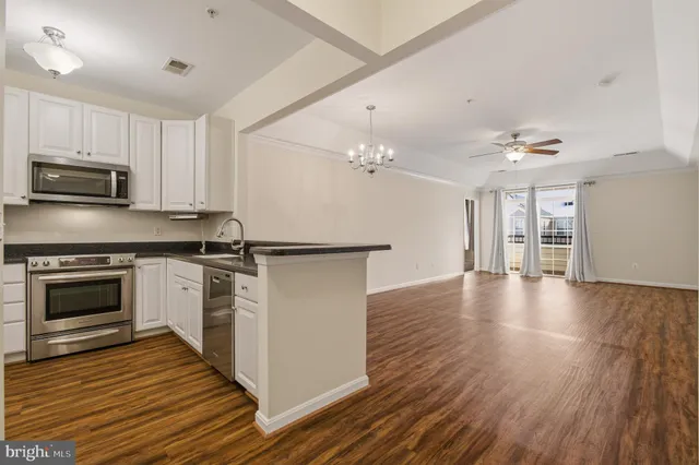 a kitchen with granite countertop a refrigerator stove and sink