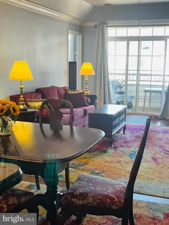 a living room with dining table and a lamp