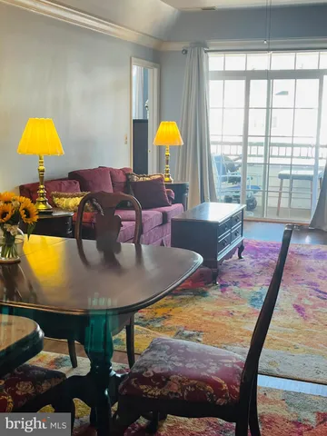 a living room with dining table and a lamp