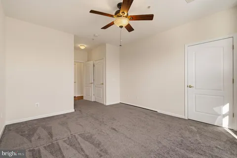 an empty room with a ceiling fan and a window
