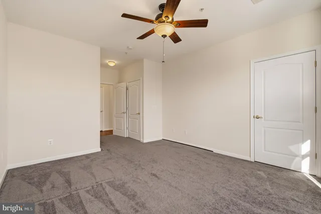 an empty room with a ceiling fan and a window