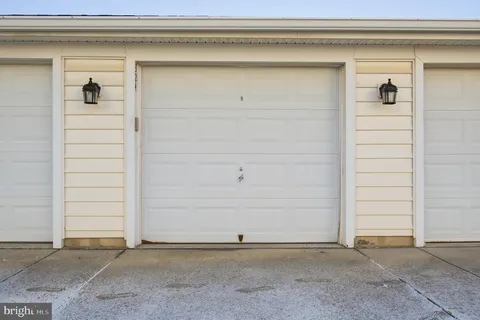 a view of a hallway with wooden floor and chandelier